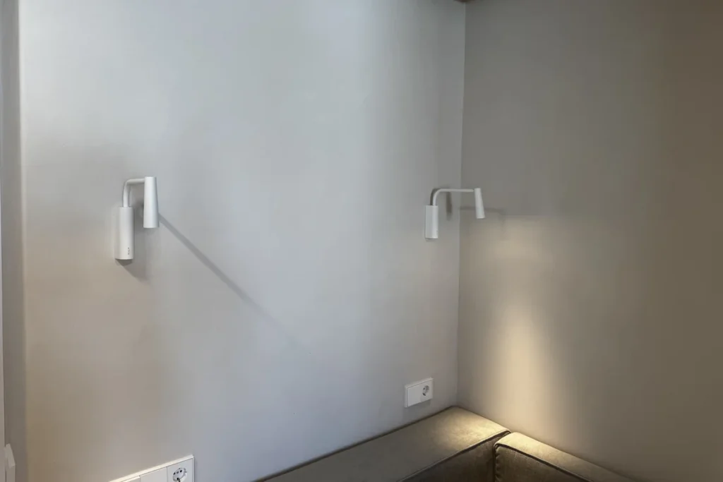 Pared con revestimiento decorativo y apliques en apartamento de Alicante